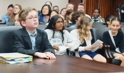 Mock Trial 4 Students sitting at lawyers table and in the audience at a mock trial.